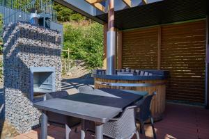 a table and chairs on a patio with a fireplace at UplandParcs Sauerland in Winterberg