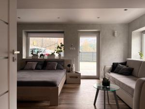 a bedroom with a bed and a couch and a table at Breńskie Tarasy in Brenna +45 photos