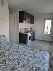 a bedroom with a bed and a kitchen with a washing machine at La Parenthèse Lémantine - Studio 3 in Neuvecelle