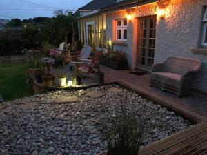 a house with a patio with a rock garden at Bradleigh Lodge in St Austell