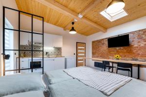 a bedroom with a brick wall and a bed and a desk at gardenSTUDIO in Děčín