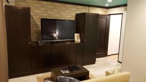 a living room with a flat screen tv on a wall at ホテルピュアゲート in Isesaki