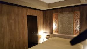 a bedroom with a bed and a wooden wall at ホテルピュアゲート in Isesaki