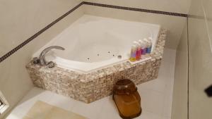 a bath tub in a bathroom with a sink at ホテルピュアゲート in Isesaki