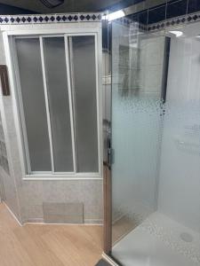a shower with a glass door in a bathroom at Villa Le Roy in Blankenberge