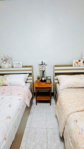 a bedroom with two beds and a wooden table at BS myhome in Sathani Hat Yai