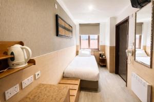a small room with two beds and a table at Eurotraveller Hotel- Express (Elephant & Castle) in London +4 photos