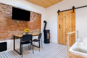 a room with a table and chairs and a brick wall at gardenSTUDIO in Děčín
