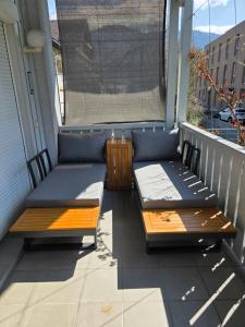 a balcony with two beds and a window at Gardenia-Altach, 2-4 P, Küche, Garten, Terrasse, Parkplatz, Wifi, Ski Stellplatz in Altach