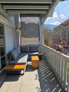 a porch with a couch and a table on a balcony at Gardenia-Altach, 2-4 P, Küche, Garten, Terrasse, Parkplatz, Wifi, Ski Stellplatz in Altach