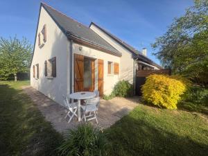 a small house with a table and chairs in the yard at Chez Raoul, maison agréable in Villebernier