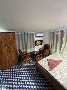 a bedroom with two beds and chairs and a fireplace at Luna leaf Homestay in Guwahati