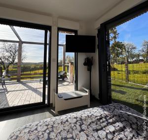 a bedroom with a bed and sliding glass doors at Le bêêêl endroit in Gélucourt