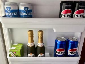 two bottles of beer and cans in a refrigerator at Maison Du Soleil in Somma Lombardo