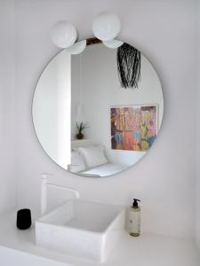 a bathroom with a mirror and a white sink at Chiara Mykonos III in Mikonos +46 photos