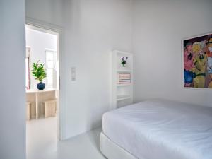 a white room with a bed and a window at Chiara Mykonos III in Mikonos