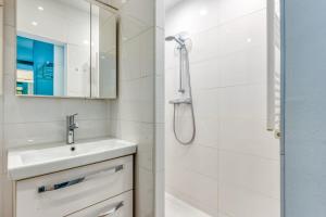 a white bathroom with a sink and a shower at Alte Teestube 55 in Norderney +9 photos