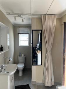 a bathroom with a white toilet and a sink at Serenity Self Catering in Windhoek +9 photos