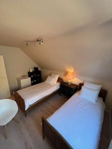 a bedroom with two beds and a table with a lamp at Silk and Stone Manor in Grez-Doiceau