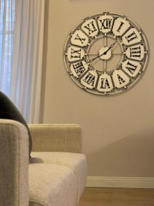 a clock hanging on a wall next to a couch at La casa di Gio in Lezzeno
