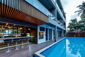 a swimming pool with a bar next to a building at Golden Pearl Tangalle Beach in Tangalle