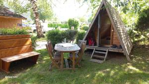 a small tent with a table and chairs in a yard at Refuge - Les Chalets du lac Belcaire in La Celle-sous-Gouzon +8 photos