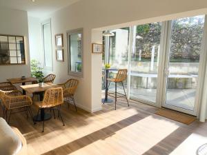 a dining room with a table and chairs and windows at Lembranza Guest House in Ponte Do Porto