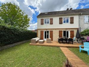 a house with a patio and a table and chairs at La maison penchée in Rosny-sous-Bois