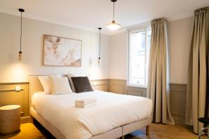 a bedroom with a white bed and a window at Studio haut de gamme - Hypercentre - Lit Queen in Caen