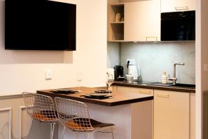a kitchen with a table with chairs and a counter top at Studio haut de gamme - Hypercentre - Lit Queen in Caen +24 photos