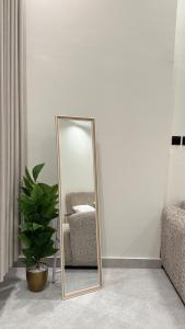 a mirror in a room with a chair and a plant at شقق المشرق in Jeddah