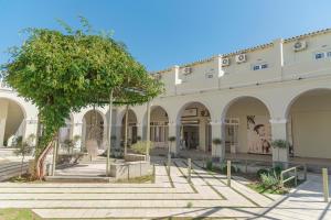 a building with a tree in front of it at Ionian Blue Beach Hotel - Adults Only in Kavos