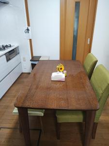 a kitchen with a wooden table with flowers on it at 天王寺まで電車にて 約10分 福宿八尾 in Yaochō