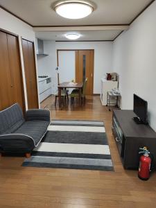 a living room with a couch and a table at 天王寺まで電車にて 約10分 福宿八尾 in Yaochō