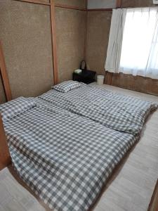a large bed in a room with a window at 天王寺まで電車にて 約10分 福宿八尾 in Yaochō +3 photos