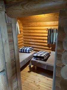 a room with two beds in a log cabin at Lakeside Cottages in Rastinniemi