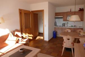 a living room with a table and a kitchen at Landhaus am See App. 2 in Pönitz am See +19 photos