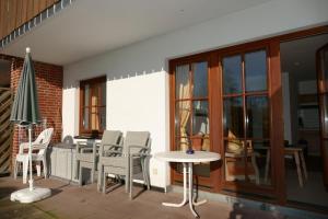 a patio with a table and chairs and a table at Landhaus am See App. 2 in Pönitz am See
