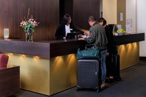 a group of people standing at a reception desk at relexa hotel Schatten Stuttgart in Stuttgart