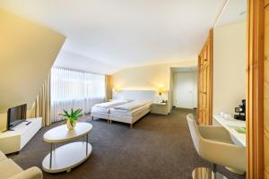 a hotel room with two beds and a living room at relexa hotel Schatten Stuttgart in Stuttgart +73 photos