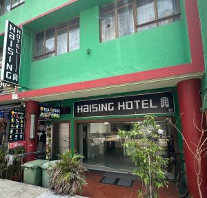 ein grünes Gebäude mit einem Haling-Hotel-Schild darauf in der Unterkunft Haising Hotel in Singapur