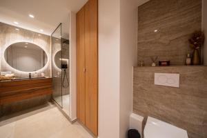 a bathroom with a shower and a toilet and a mirror at Appartement luxe vue mer et collines avec piscine in Mandelieu-La Napoule