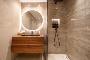 a bathroom with a shower with a sink and a mirror at Appartement luxe vue mer et collines avec piscine in Mandelieu-La Napoule