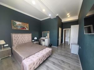 a bedroom with a large bed and blue walls at Gabala Comfort Inn in Gabala