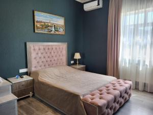 a bedroom with a large bed with a pink headboard at Gabala Comfort Inn in Gabala