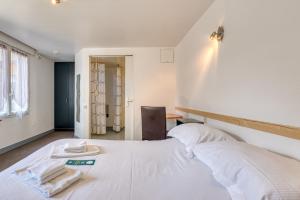 a bedroom with a white bed with towels on it at Logis Hôtel Sea View in Saint-Gilles-Croix-de-Vie