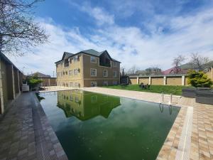 a pool of water in front of a house at Gabala Comfort Inn in Gabala
