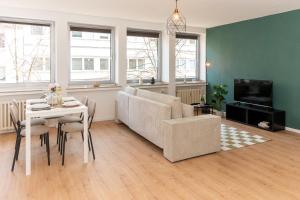 a living room with a couch and a table at Modernes Apartment im Essener Stadtkern mit Parkplatz in Essen +15 photos