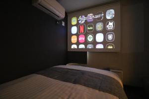 a room with a bed and a tv with an iphone screen at TAKETO STAY PREMIERE SAPPORO EKi in Sapporo