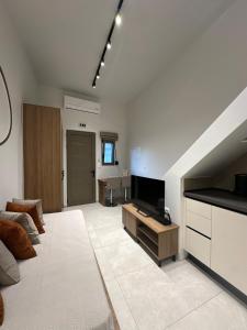 a living room with a couch and a flat screen tv at Modern Lofts in Archangelos Rhodes with Parking - Equus - 3 Guests in Archangelos